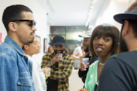 a group of people talking to each other in an art gallery