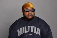 a black man wearing sunglasses and a hat